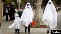 FILE - On Halloween, a family of ghosts walk in a neighborhood in Sierra Madre, California, U.S., on October 31, 2017. (REUTERS/Mario Anzuoni)