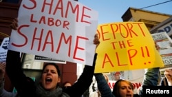 Women hold posters bearing messages against the Australian Labor Party during a rally in support of asylum seekers in Sydney July 22, 2013.