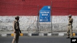 Indian policemen stand guard outside the residence of National Conference president Farooq Abdullah in Srinagar, Indian controlled Kashmir, Sept. 16, 2019. 