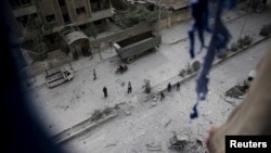 People inspect the damage at a site hit with airstrikes by pro-Syrian government forces in the rebel held Douma neighborhood of Damascus, Syria, Feb. 14, 2016.