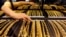 FILE - An employee arranges gold jewelry in a display case as her arm is reflected in the mirror, at a gold shop in Wuhan, Hubei province, Aug. 25, 2011. 