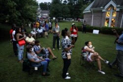 FILE - Voters, some wearing masks, line up at a polling station during recent Democratic and Republican primaries during the coronavirus pandemic, in Union City, Georgia, June 9, 2020.