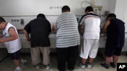 FILE - In this July 24, 2008 file photo, obese patients wash their plates after lunch at the Aimin Fat Reduction Hospital in Tianjin, China. 