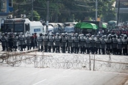 Riot police line up during a protest against the military coup demanding the release of elected leader Aung San Suu Kyi, in Yangon, Myanmar, Feb. 6, 2021.