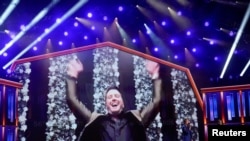 Luke Bryan reacciona en un video de aceptación digital después de ganar el premio Artista del Año mientras Mickey Guyton y Keith Urban miran en la 56a entrega de los premios ACM en el Grand Ole Opry, en Nashville, Tennessee, EE.UU., el 18 de abril de 2021