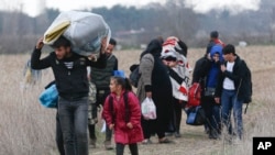 Migrants walk near Pazarkule at the Turkish-Greek border on Thursday, March 5, 2020.