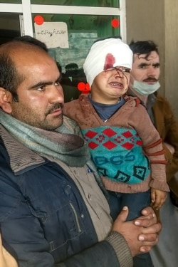 A Pakistani Kashmiri carries an injured child at a hospital following cross-border shelling between Pakistani and Indian forces in Tehjain village at the Line of Control in Neelum Valley, Pakistan-administered Kashmir, Nov. 13, 2020.