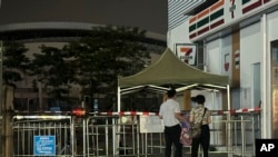 FILE - People look at barriers at the entrance where a man deliberately rammed his car into people exercising, killed some and injured others in Zhuhai in southern China's Guangdong province, Nov. 12, 2024.