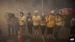Members of the 'Wall of Moms' protest group lock arms as they are tear-gassed by federal officers during a Black Lives Matter protest at the Mark O. Hatfield United States Courthouse, July 27, 2020, in Portland, Ore.