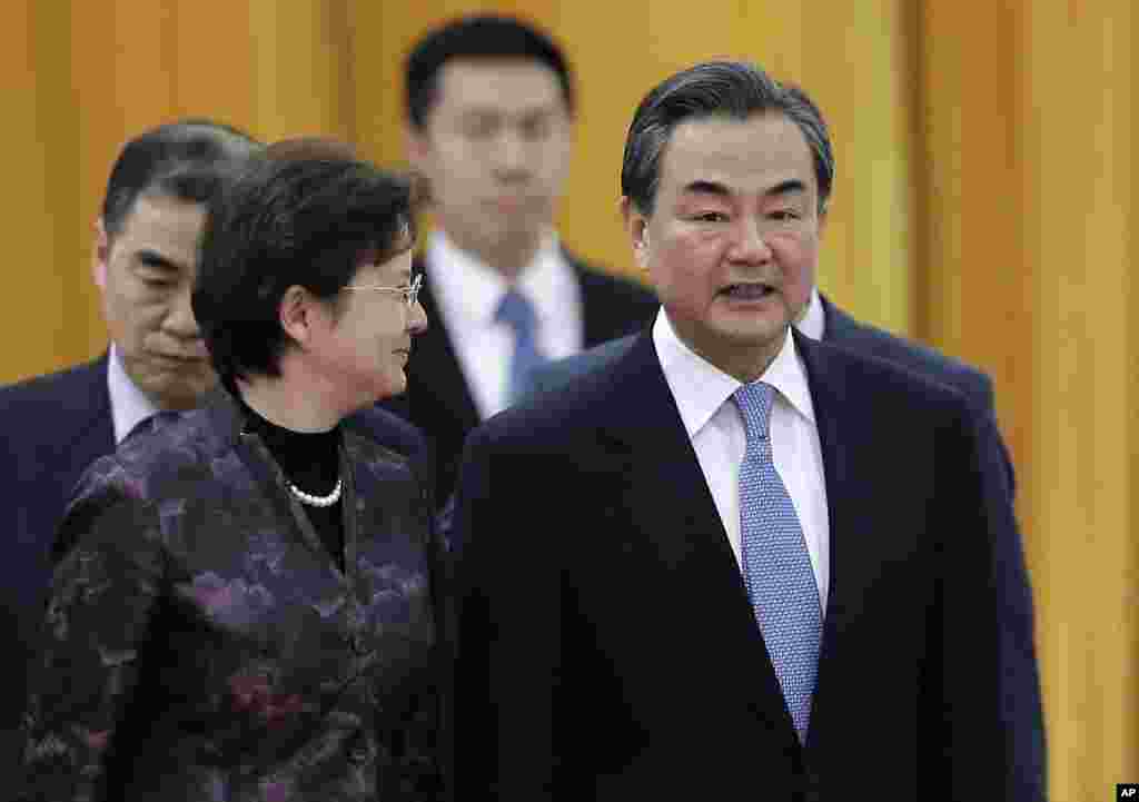 Chinese Foreign Minister Wang Yi (right) chats with a delegate as they attend a ceremony. China told the U.S. that it is against cyber attacks and opposes any nation or individual launching such attacks from a third country, but did not directly condemn the Sony hackings, at the Great Hall of the People in Beijing, China. Dec. 22, 2014.