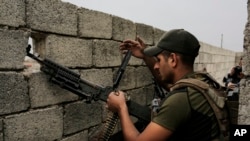 A soldier with the Iraqi special forces reloads his weapon on a rooftop in west Mosul as fighting between Iraqi troops and the Islamic State group continues, April 23, 2017.