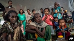 Displaced women who fled from the town of Samre, roast coffee beans over a wood stove at the Hadnet General Secondary School which has become a makeshift home to thousands displaced by the conflict, in Mekele, in the Tigray region of northern Ethiopia.