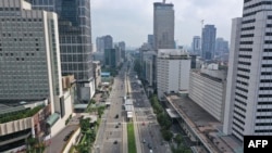 FILE - This aerial photo taken in Jakarta on April 14, 2020 shows few vehicles on Thamrin road leading to the usually congested Hotel Indonesia (HI) roundabout on the fifth day of large-scale social restrictions amid the COVID-19 pandemic in Jakarta. 