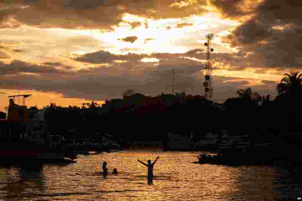 Los migrantes que esperan para cruzar hacia Capurganá acampan por la costa en improvisadas casas de campaña y se bañan en el mar.