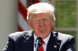 FILE - President Donald Trump pauses as he announces his decision that the United States will withdraw from the landmark Paris Agreement, in the Rose Garden of the White House in Washington, June 1, 2017.