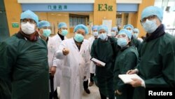 Para ahli dari China dan tim gabungan Organisasi Kesehatan Dunia (WHO), mengenakan masker saat mengunjungi Rumah Sakit Tongji Wuhan di Wuhan, di provinsi Hubei, China 23 Februari 2020. China Daily via REUTERS.