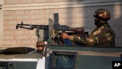 Indian security officers keep guard near the site of an attack on the outskirts of Srinagar, Indian-controlled Kashmir, Nov. 26, 2020. 