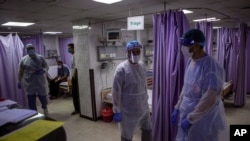 Palestinian doctors treat patients at the emergency room of the al-Quds Hospital in Gaza City, Monday, Sept. 7, 2020. Dozens of front-line health care workers have been infected, dealing a new blow to overburdened hospitals. 