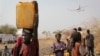 FILE - A displaced South Sudanese woman carries a plastic jerry can with water in the United Nations camp that has become home to thousands of displaced people in Malakal, South Sudan.