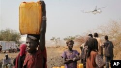 FILE - A displaced South Sudanese woman carries a plastic jerry can with water in the United Nations camp that has become home to thousands of displaced people in Malakal, South Sudan.