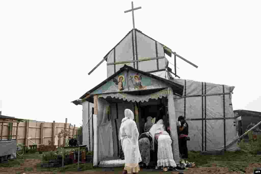 Migran Kristen Koptik Ethiopia tiba untuk melakukan misa di gereja Orthodox darurat di kamp &quot;Jungle&quot; di kota Calais, Perancis utara.