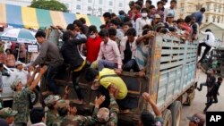 Cambodian migrant workers get off from a Thai truck upon their arrival from Thailand at a Cambodia-Thai international border gate in Poipet, Cambodia, Tuesday, June 17, 2014. 