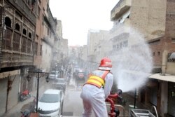 A volunteer sprays disinfectant in an effort to curb the spread of coronavirus outbreak in Peshawar, Pakistan, March 23, 2020.