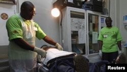 FILE - A doctor (L) performs circumcision on an unidentified politician in an effort to reduce the spread of HIV, in Harare, Zimbabwe, June 22, 2012.