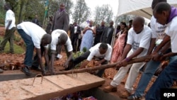 Des volontaires déposent dans un caveau les restes de victimes du génocide de 1994, à Murambi, est du Rwanda, 07 avril 2005. epa / RICKY GARE