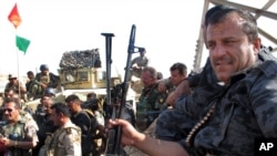 File - Members of the Kurdish security forces gather in an area in Kirkuk, Iraq. In Iraq's chaos, the Kurds are emerging as significant winners, June 14, 2014.