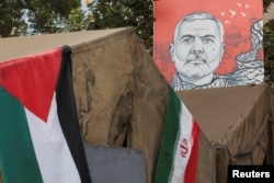 Spanduk bergambar mendiang pemimpin Hamas Ismail Haniyeh berada di samping bendera Iran dan Palestina di Teheran, Iran, 12 Agustus 2024. (Foto: Majid Asgaripour/WANA via REUTERS)