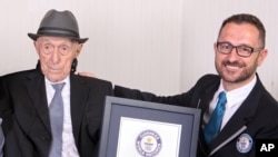 In this photo supplied by Guinness World Records, Marco Frigatti, head of records for Guinness World Records, presents Israel Kristal a certificate for being the oldest living man, in Haifa, Israel, March 11, 2016. 