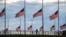 A jogger passes flags flying at half-staff at the Washington Monument on the National Mall following the death of former U.S. President Jimmy Carter, in Washington, Dec. 30, 2024. 