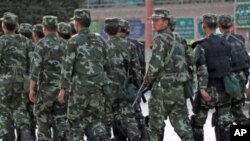 Armed police officers patrol an ethnice Uighur area in Kashgar, in Xinjiang province Aug. 4, 2011.