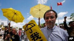 Pro-democracy protesters holding yellow umbrellas attend a rally outside the Legislative Council in Hong Kong, Wednesday, June 17, 2015.