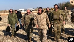 Gen. Frank McKenzie, center front, the top U.S. commander for the Middle East, visits a military outpost in Syria, Jan. 25, 2020. 