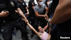 FILE - Riot police detain a demonstrator as LGBTQ rights activists try to gather for a Pride parade, which was banned by local authorities, in central Istanbul, Turkey, on June 26, 2021. 