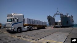 U.S. Army soldiers stand next to arriving trucks loaded with humanitarian aid at the U.S.-built floating pier before reaching the beach on the coast of the Gaza Strip, June 25, 2024. The pier was removed on June 28 due to weather, and it is unknown whether it will be reinstalled.