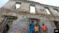 Internally displaced children stand outside a decrepit building they are using as a temporary home in the Hodan district of Somalia's capital Mogadishu, September 6, 2011.