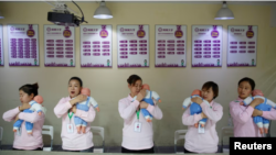 FILE - Potential nannies learn how to care for newborns at a training school in Beijing on Dec 5, 2018.
