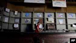 FILE - In this Oct. 9, 2009, photo, an employee works in a government food store with empty shelves in Havana, Cuba. The Cuban government said May 10, 2019, that it would begin rationing chicken, eggs, rice, beans, soap and other basic products in the face of a economic crisis.
