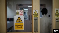 FILE - An employee walks through a door at a hospital in Nairobi, Kenya, April 24, 2020. Security is being increased at children's homes and hospitals in Kenya after three medical officers were charged Nov. 18, 2020, with child trafficking. 