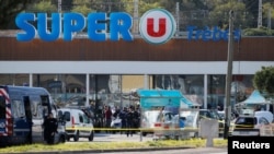 Gendarmes and police officers investigate the scene at a supermarket after a hostage situation in Trebes, France, March 23, 2018.