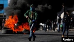 Un manifestant palestinien court pendant les affrontements avec les troupes israéliennes, près de la colonie juive de Beit El, près de Ramallah. 8 décembre 2017. 