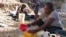 A woman mixes Clorox with water to drink in Port-au-Prince, Haiti, on April 3, 2020. Some Haitians believe the mixture can prevent them from COVID-19 infection.