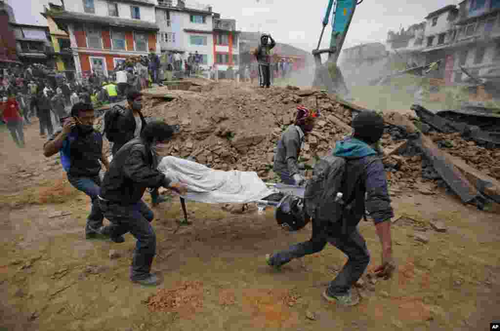 Volunteers carry the body of a victim on a stretcher after an earthquake in Kathmandu, Nepal, April 25, 2015.
