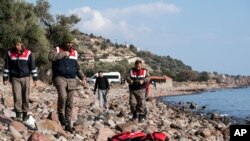 Petugas paramiliter Turki berdiri dekat jenazah migran di pantai dekat kota Ayvacik, Canakkale, Turki, 30 Januari 2016. 