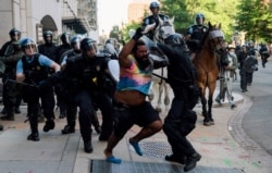 Riot police chase a man as they clear Lafayette Park and the area around it across from the White House for President Donald Trump to be able to walk through for a photo opportunity in front of St. John's Episcopal Church, June 1, 2020.