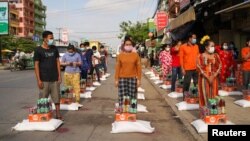 Workers receive food donations inside a 'red zone', which has stricter lockdown measures imposed due to the coronavirus disease (COVID-19) outbreak, in Phnom Penh, Cambodia, April 28, 2021. REUTERS/Cindy Liu