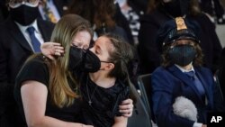 Abigail Evans, 7, and Logan Evans, 9, the children of the late Capitol Police officer William "Billy" Evans, sit with their mother Shannon Terranova, left, during a memorial service as Evans lies in honor in the Rotunda at the U.S. Capitol in Washington.